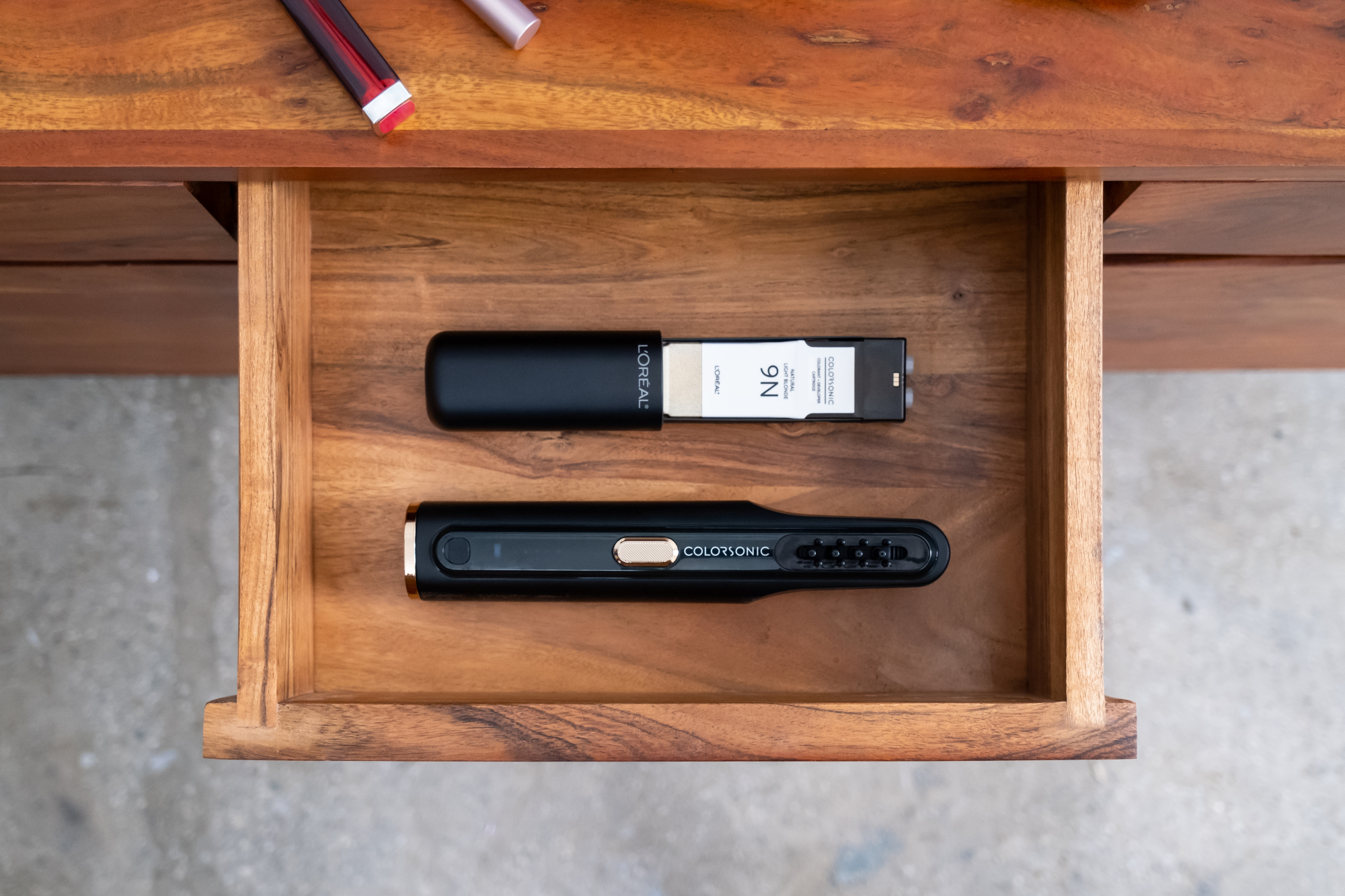 A wand-like device in two pieces sitting inside a wooden drawer.