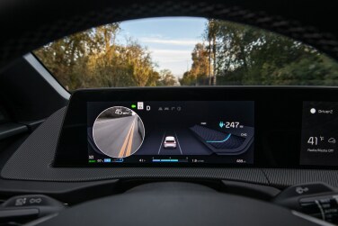 The screen behind the steering wheel showing a video of the backside of the car.