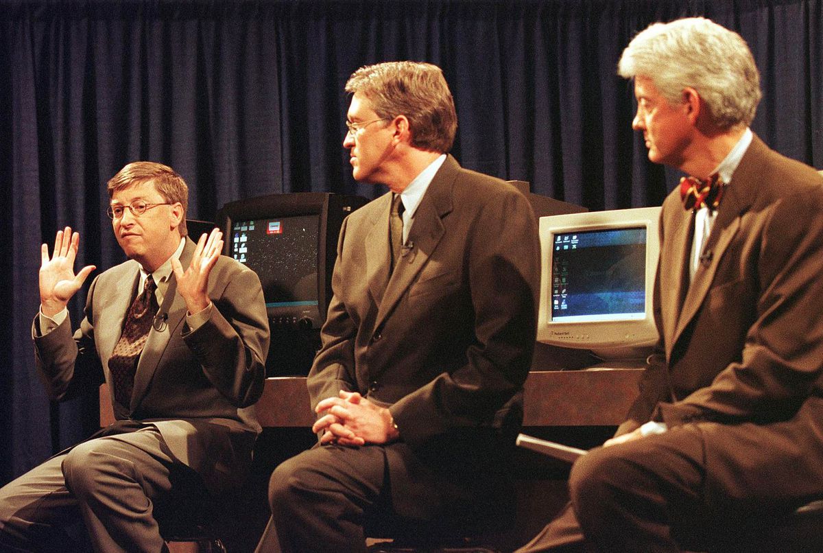 Microsoft co-founder Bill Gates, with executives Jeff Raikes (center) and Bill Neukom (right), talks about the Department of Justice’s antitrust lawsuit in 1998.