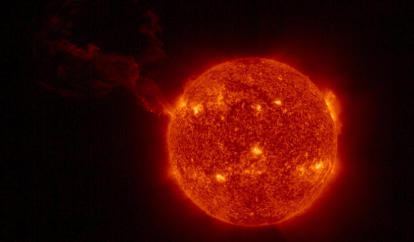 A look at the sun, with a large plume of plasma visibly erupting in a wide, looping arc in the top left quadrant of the image.