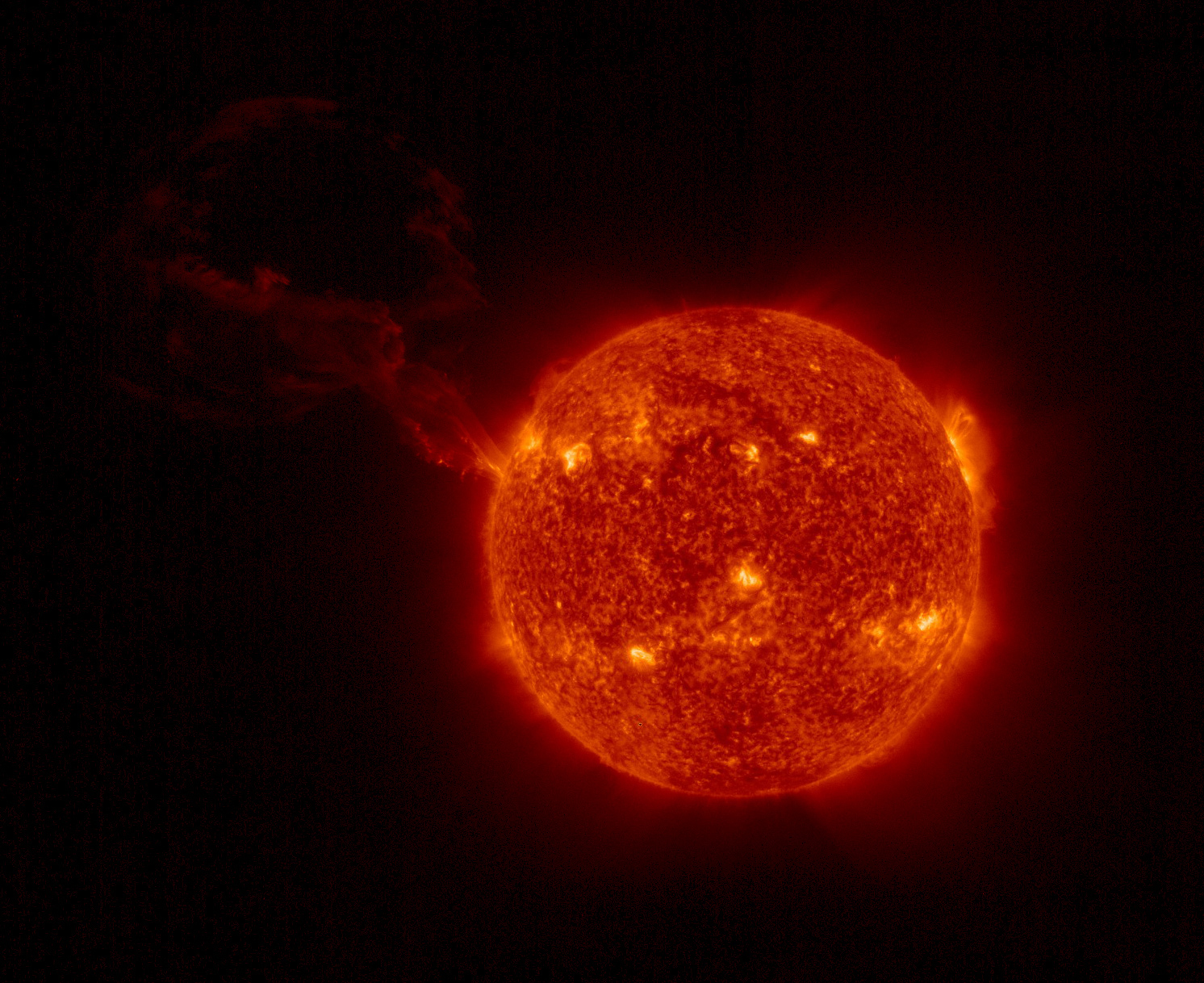 A look at the sun, with a large plume of plasma visibly erupting in a wide, looping arc in the top left quadrant of the image.