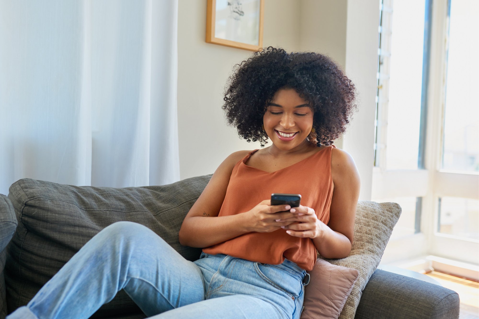 Woman on couch looking at phone