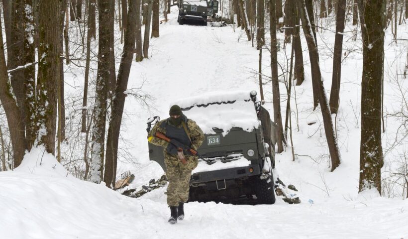 A member of the Ukrainian Territorial Defense Forces walks past destroyed Russian military vehicles in a forest outside Ukraine’s second-largest city of Kharkiv on March 7, 2022.