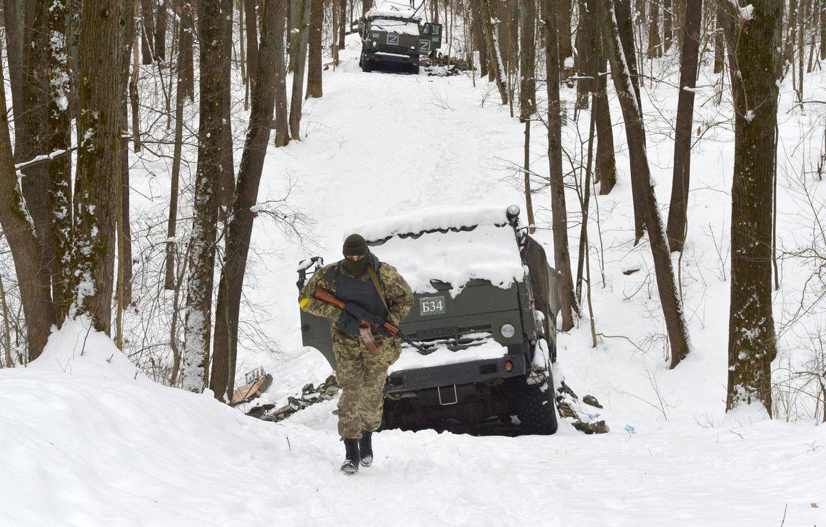 A member of the Ukrainian Territorial Defense Forces walks past destroyed Russian military vehicles in a forest outside Ukraine’s second-largest city of Kharkiv on March 7, 2022.