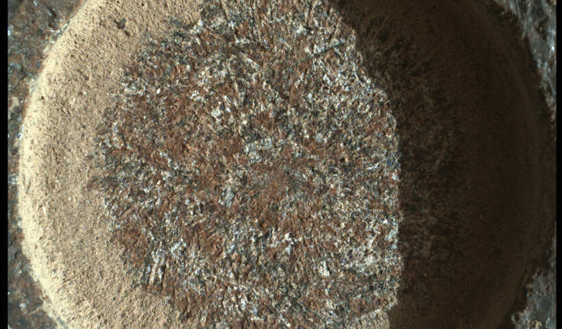 A close-up view of a Mars rock with a particular focus on the circular abrasion pattern created by NASA's Perseverance rover.