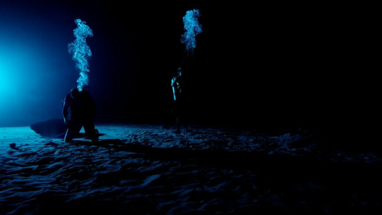 NASA divers training in a dark environment