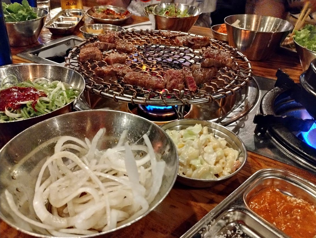 A night mode photo from the Stylus 5G of Korean BBQ and condiments