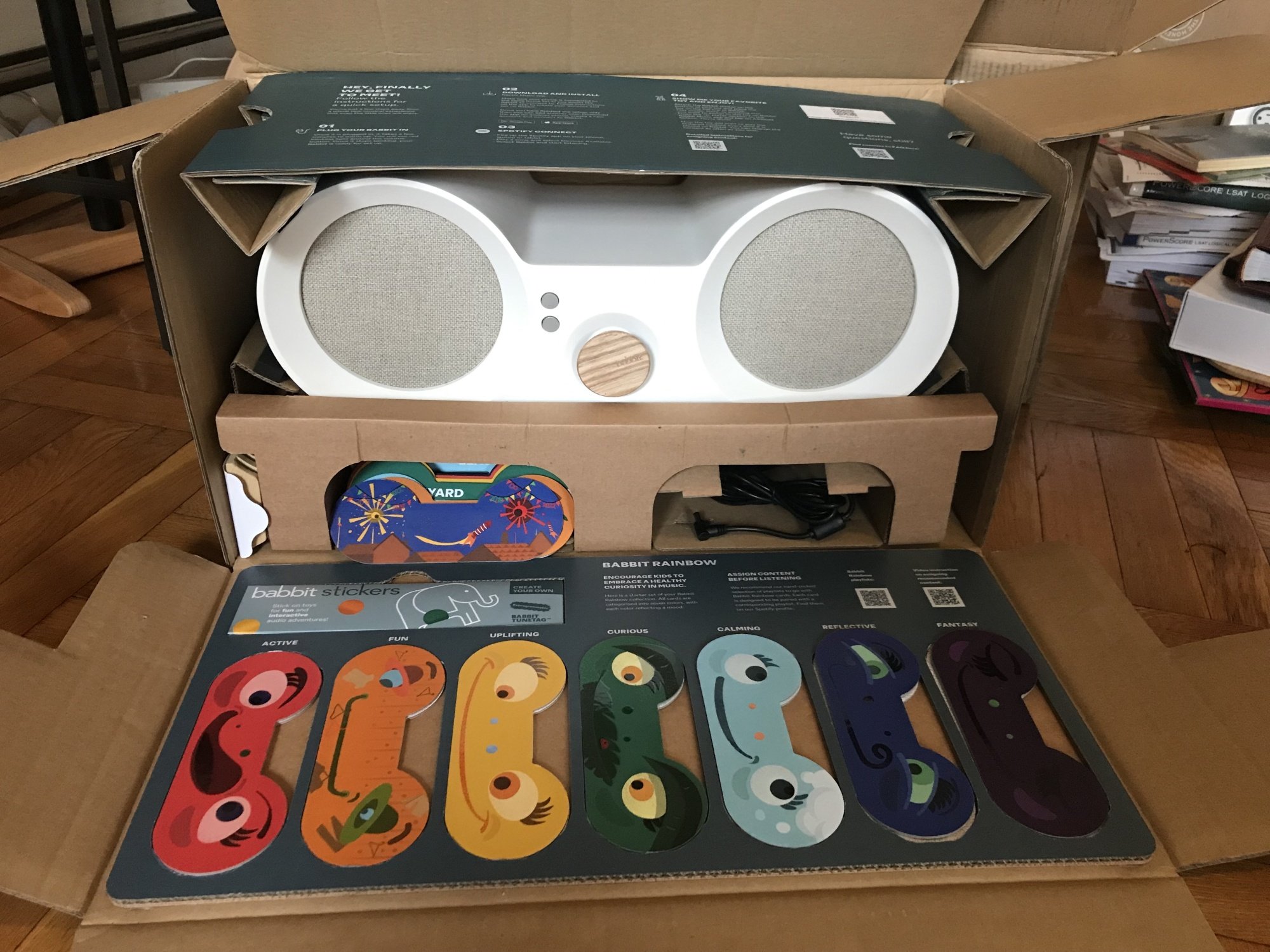 A speaker in a box with rainbow cards in front of it